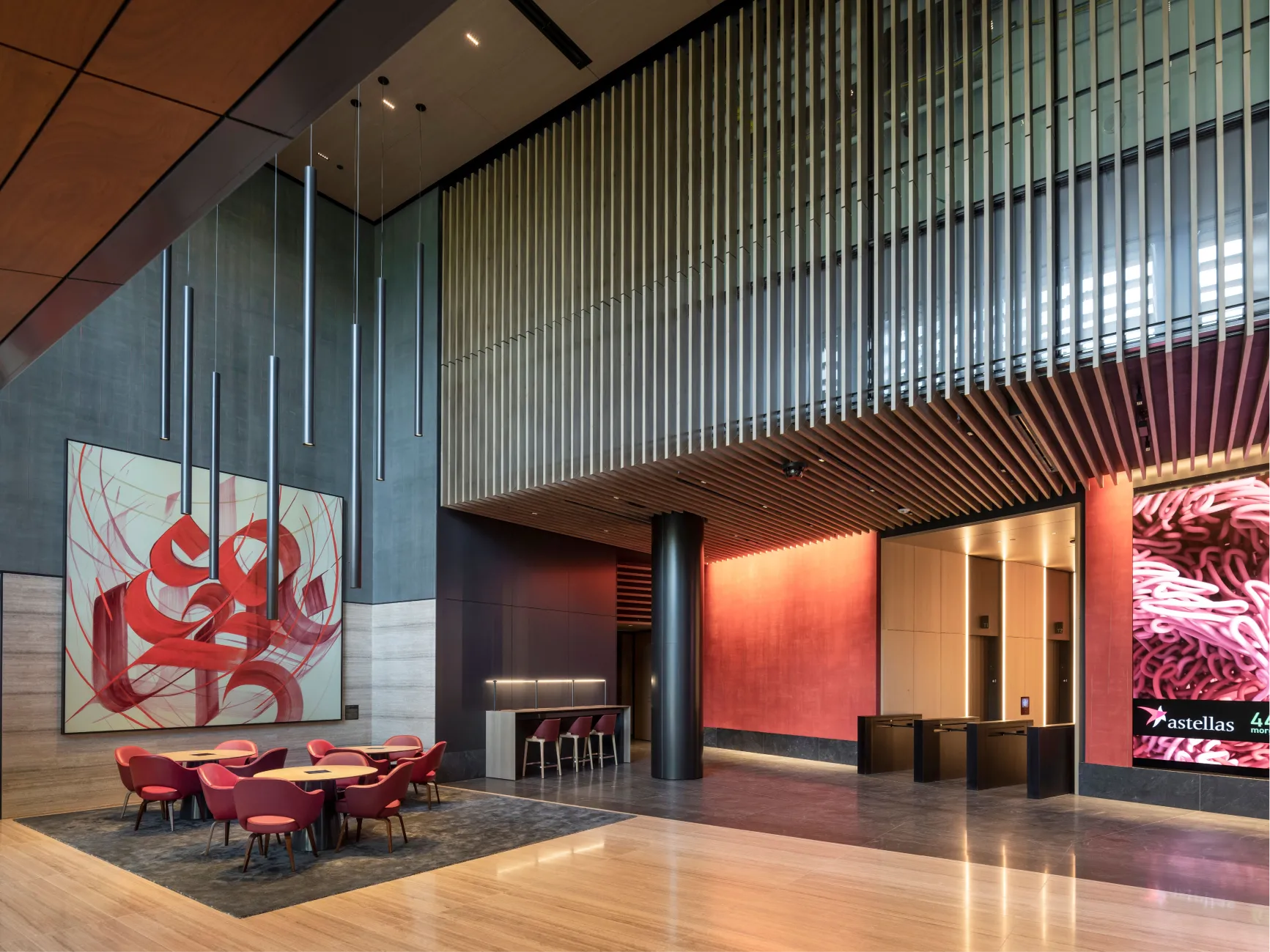 Contemporary corporate interior featuring lounge seating wood ceiling slats and elevator lobby with access control