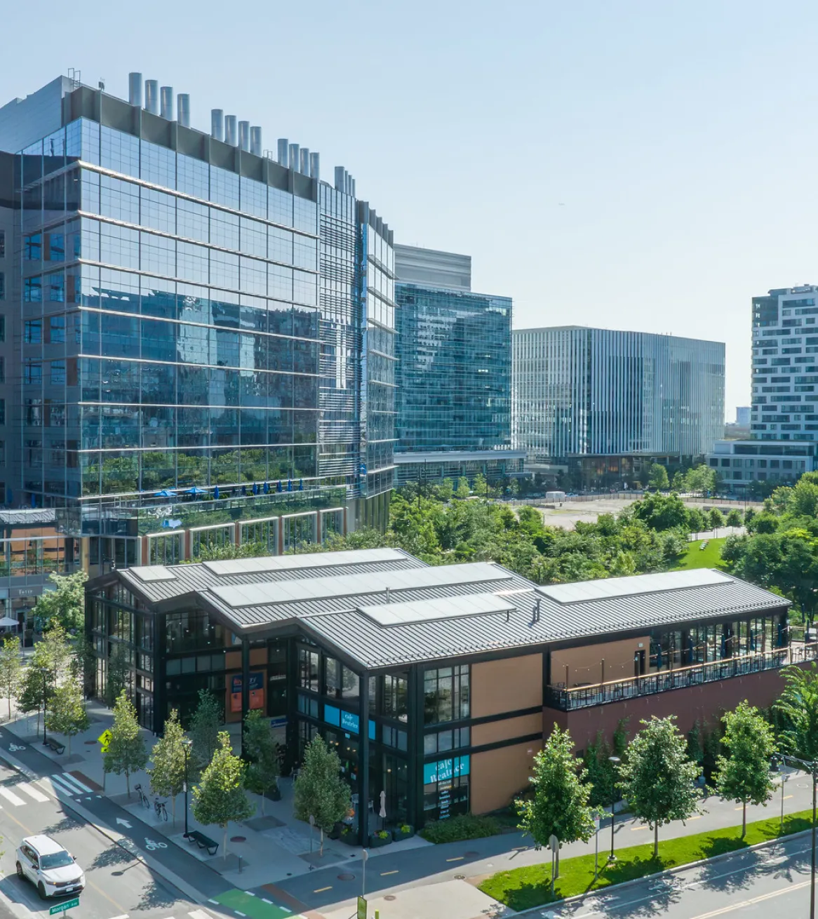 Cambridge Crossing district with modern glass office buildings retail pavilion and landscaped green space