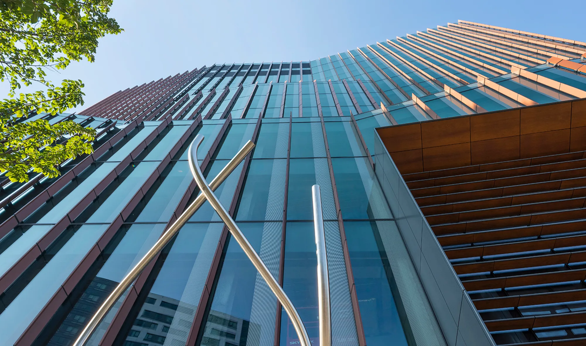 Low angle perspective of contemporary facade with reflective glass panels and vertical architectural elements